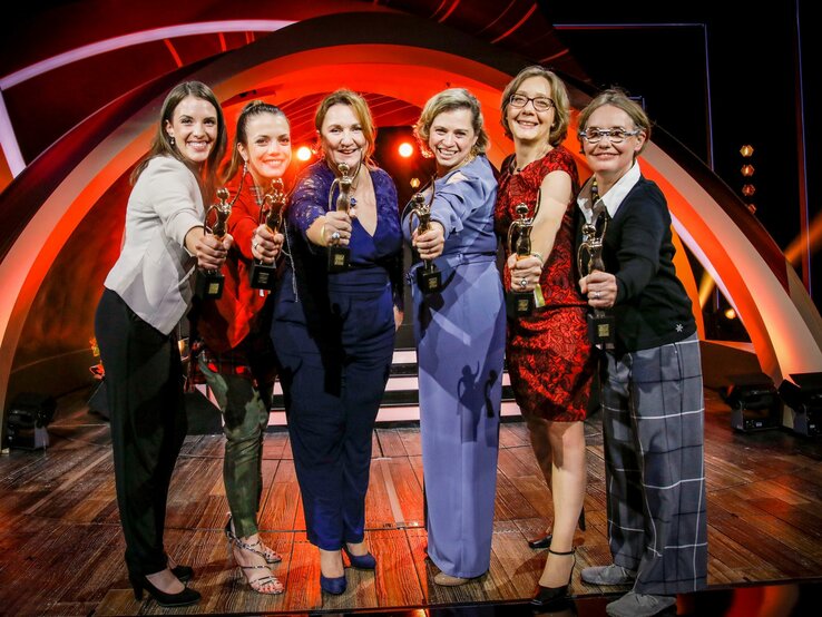 Sechs Preisträgerinnen der GOLDENEN BILD der FRAU-Gala 2019 halten in Abendgarderobe ihren goldenen Preis in die Kamera.